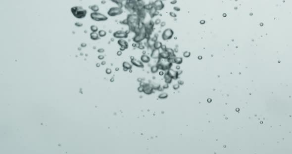 Liquid Being Poured Into Water Creating Rising Bubbles alt