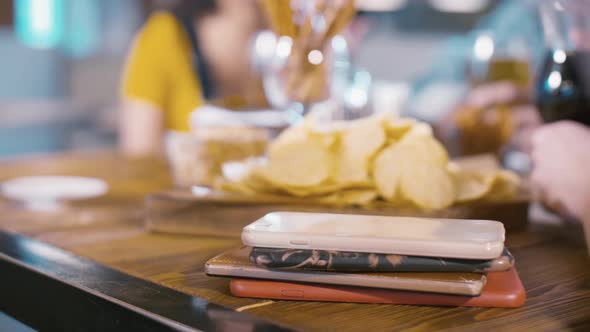 Mobile phones laying one upon the other on wood table inside bar