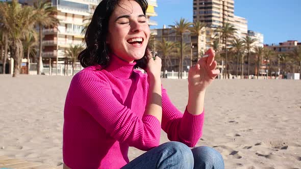 Young Woman Smokes a Cigarette on the Beach and Smile