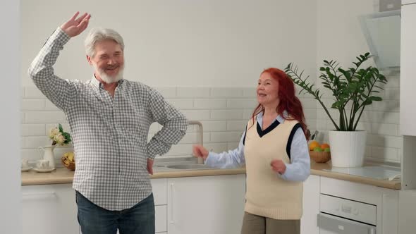 Loving Senior Couple 5060 Years Old During a Fun Dance in the Kitchen alt