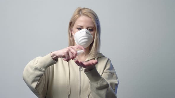 Blonde woman in protective mask with disinfection gel alt