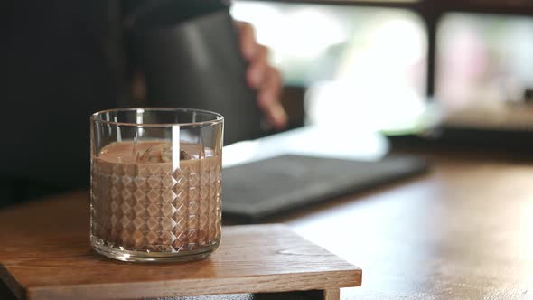 4K Asian woman barista make iced chocolate with froth milk serving to customer alt