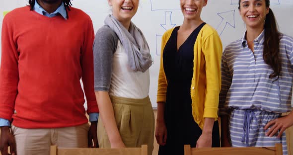 Happy business executive standing together in office alt