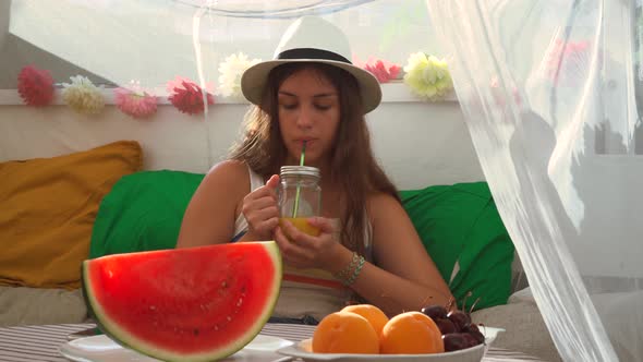 Woman drinking fresh juice from glass jar alt