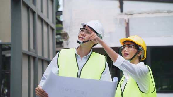 Asian construction workers people wear protective helmet hold drawing, work onsite of architecture. alt