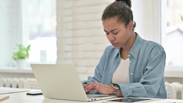 Young African Woman with Headache Working on Laptop alt