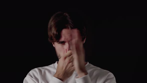 Trendy Young Man covering nose from stench, smelling gesture, close, black background alt