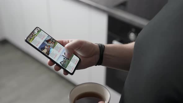 A Man Chooses a New Home for Himself Through an Application on a Smartphone alt