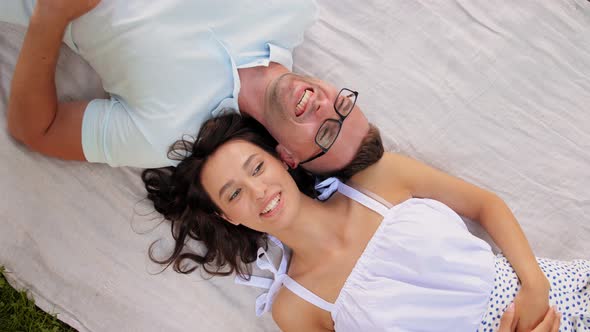 Happy Couple Lying on Picnic Blanket alt