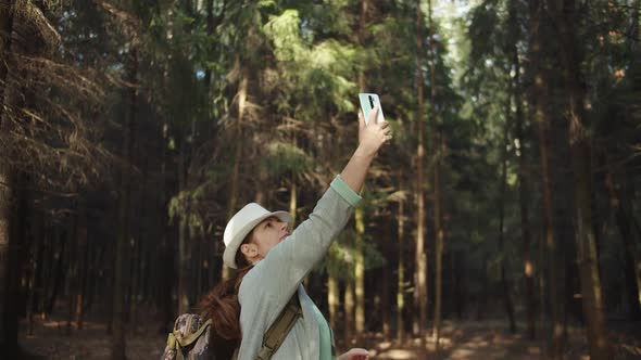 Traveler Woman Trying To Catch a Cell Signal on the Phone in the Forest, No Signal on the Phone