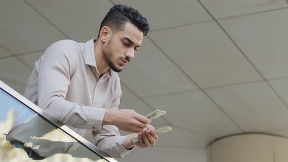 Young Arabian Hispanic Successful Business Man Counting Money Standing on Balcony Terrace alt