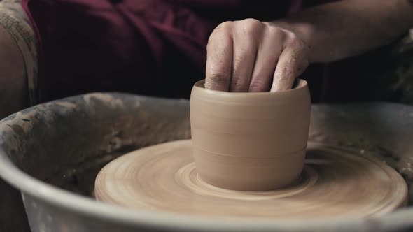 The Hands of a Potter Creating an Earthen Jar on the Circle Closeup Hands on Circle with Clay alt
