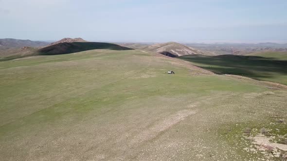 Green Hills and a Group of Cyclists with a Car alt