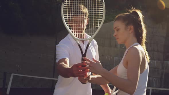 Woman and man playing tennis on a sunny day alt