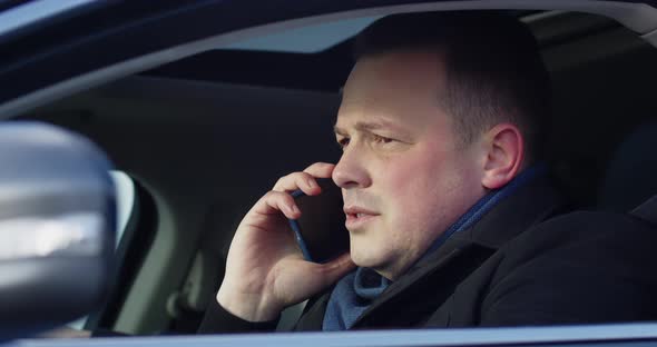 Businessman Drives A Car And Answers A Phone Call alt