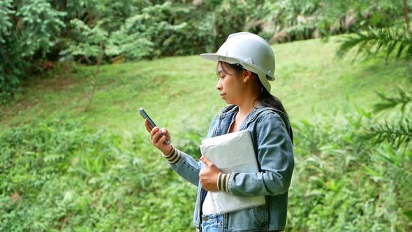 Female ecologist in safety hat working and controlling a quality of water alt