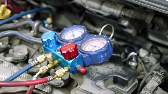 Under Hood of Open Car Lies System of Manometers for Refueling Air Conditioner alt