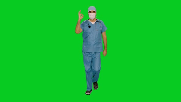 Surgeon in Mask and Uniform Showing Okay Sign while Walking on Green Screen