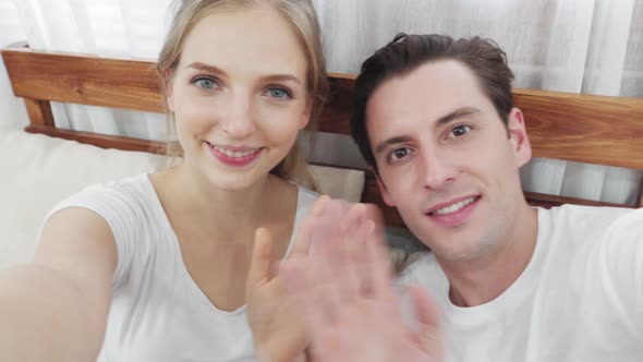 Caucasian smiling couple video calling to family at home