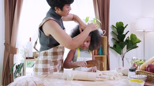 African American mom with little adorable daughters thresh dough  together