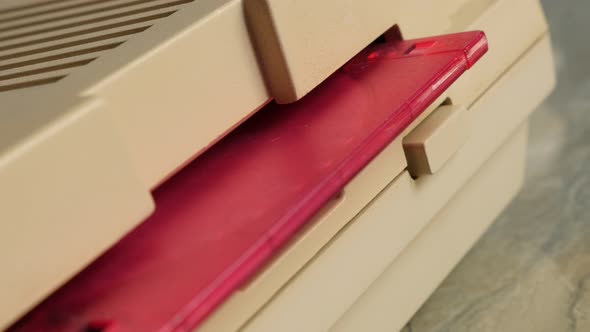 Inserting plastic pink floppy disk in  retro style personal computer 4K 2160p UltraHD footage - Disc alt