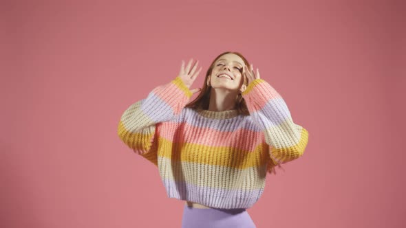 Young Female Model in a Pullover Poses for the Camera on an Isolated Background