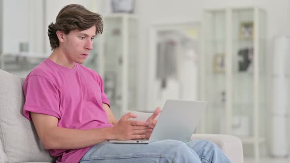 Upset Young Casual Man Reacting to Loss on Laptop at Home alt