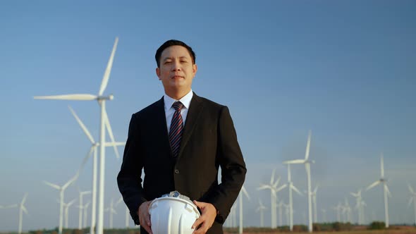 businessman is smiling proudly at the wind power project