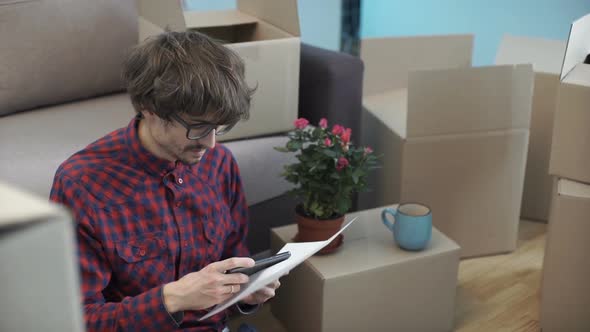 A Man Unpacks Boxes After Moving to a New Apartment