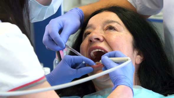 Dentist Provides Oral Irrigation for Client alt