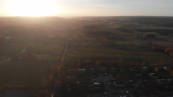Vast Farm Land and Long Straight Road Outside Town Sunset Aerial