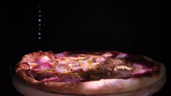 Delicious Fresh Italian Pizza On A Black Background With The Effect Of Light Inscription Pizza