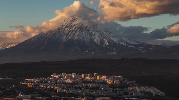 Top View of Cityscape on Background Clouds Drifting Across Sky and Volcano