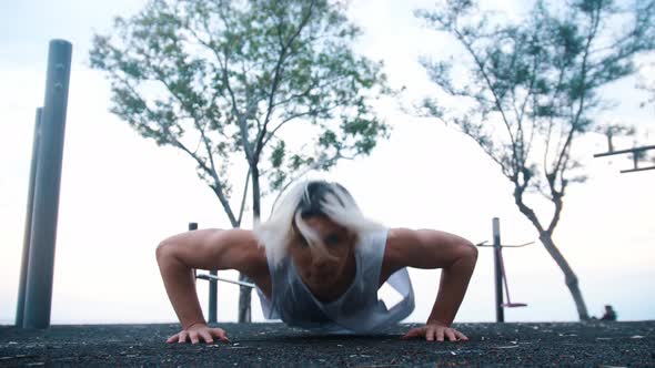 Young Man Doing Push Ups on the Outdoors Sports Ground alt