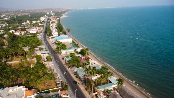 Coastal main road of Mui Ne with luxury hotels and buildings, aerial view alt