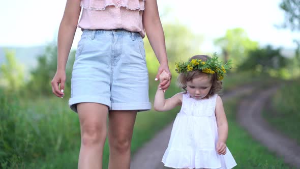 Happy Mother and Daughter with the Flower Wreath Walk in the Countryside alt