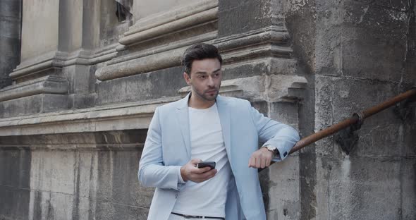 Young Man Looks At The Phone, Waiting For A Call alt