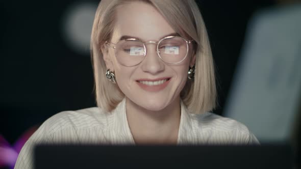 Smiling Business Woman Surfing in Social Networks on Laptop in Night Office alt