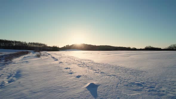 Aerial Drone View of a Fields Covered with Winter Snow during Sunset