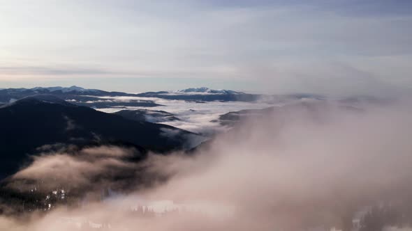 Drone Rising Above Clouds in Winter Mountain Valley