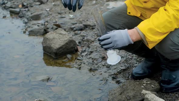 Ecology is modern. expert pours water from river into a test tube for analysis. alt