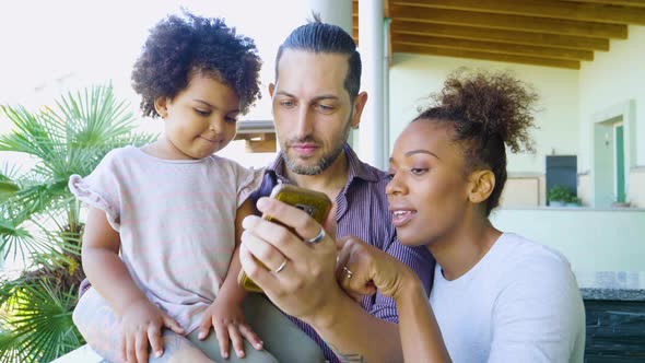 Slow motion shot of family using smartphone on balcony alt