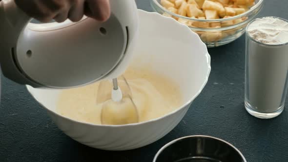  Woman's Hands with Mixer Whip Eggs To a Froth in White Bowl. Cooking Apple Pie.