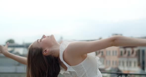 Portrait of the Young European Woman with Nose Earring in White Dress in the City She Smiles alt