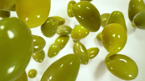 Super Slow Motion Shot of Falling Fresh Green Olives on White Background at 1000 Fps alt
