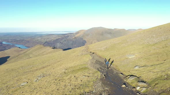 Aerial view of people hiking and climbing Snowdon mount in Wales on a sunny d