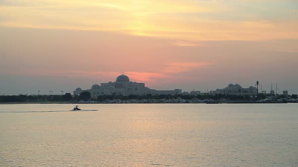 Enchanting Sunset in Abu Dhabi in a Cloudy Day with Silhouettes of Boats in the Sea alt