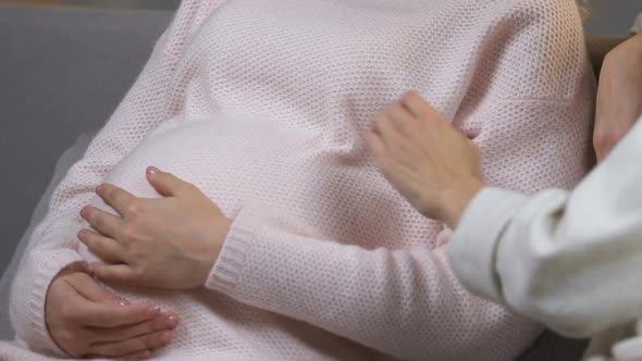 Caring Mother Supporting Her Pregnant Daughter Stroking Her Tummy, Family alt