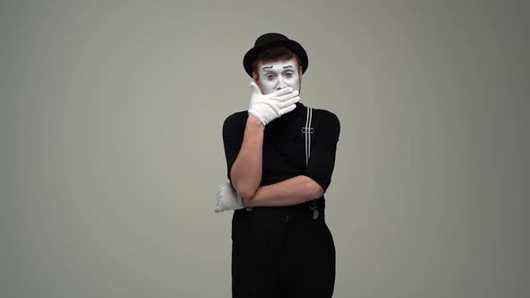 Portrait of Tired Male Mime Listening Yawning Covers Mouth with Hand and Makes Gesture with Hand alt