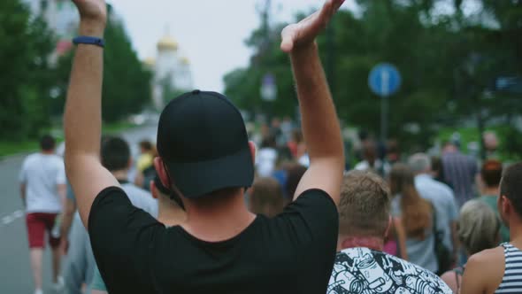 Political activist marches with protest people on demonstration, man applauds. alt